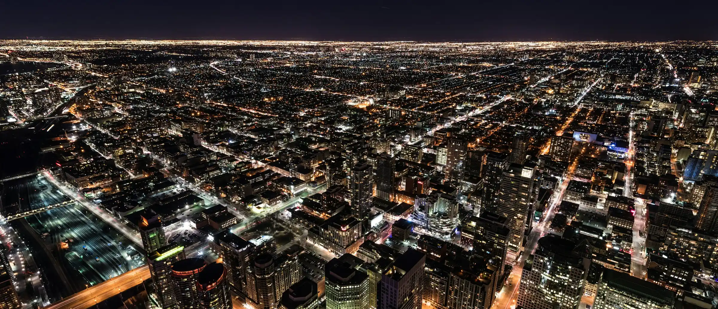 A city at night from the air, its street grid picked out in light.